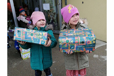 Strahlende Kinderaugen auch beim Geben: Die Kinder des Kindergarten Parz bringen ihre selbstge-packten Geschenke in den Lieferwagen für die Reise nach Rumänien.